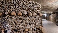 Beinhaus: Knochen und Totenschädel sind in einer Wand gestapelt