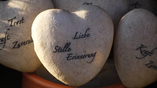 Weißer Stein mit der Aufschrift: "Liebe, Stille, Erinnerung".
