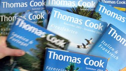 Mehrere Reiseprospekte von Thomas Cook.