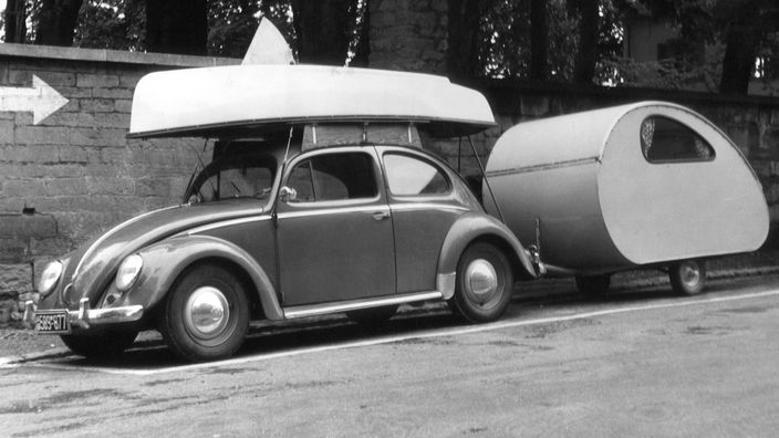 VW Käfer mit Segelboot und Wohnwagen, 1956