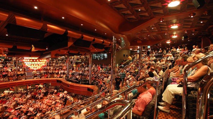 Ein voll besetztes Theater in einem Kreuzfahrtschiff.