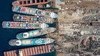 Drohnenaufnahme von mehreren Kreuzfahrtschiffen, die nebeneinander am Dock liegen