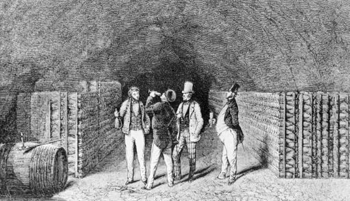 Holzstich: Vier Herren in einem Gewölbekeller bei der Weinprobe.
