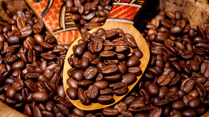 Kaffeebohnen in Großaufnahme in einer Holzschale. | Bildquelle: Mauritius Kaffeebohnen in Großaufnahme in einer Holzschale.