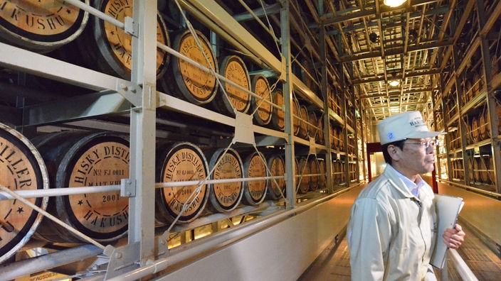 Große Whiskyproduktionshalle mit japanischem Arbeiter.