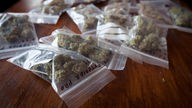 Auf einem Tisch liegen Tütchen in denen Cannabis abgepackt ist.