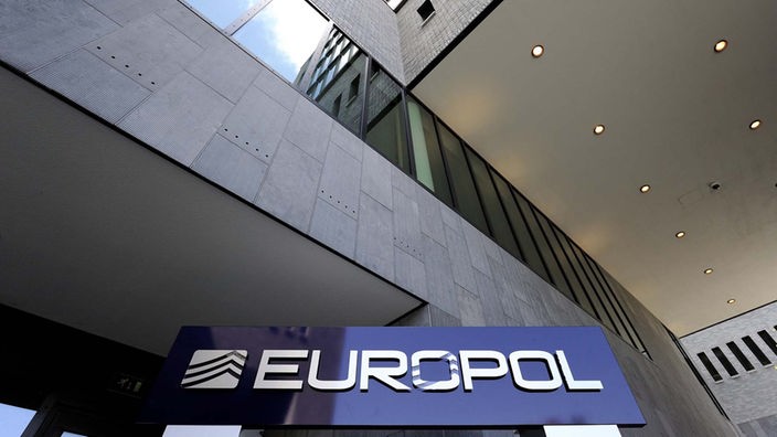 Blaues Schild mit Aufschrift 'Europol, Europol-Zentrale in Den Haag