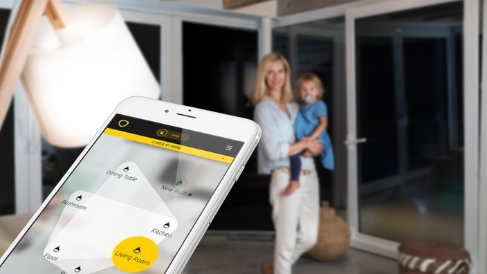 Ein Smartphone im Vordergrund, ein Mutter mit Kleinkind im Hintergrund. | Bildquelle: Comfylight Ein Smartphone im Vordergrund, ein Mutter mit Kleinkind im Hintergrund.