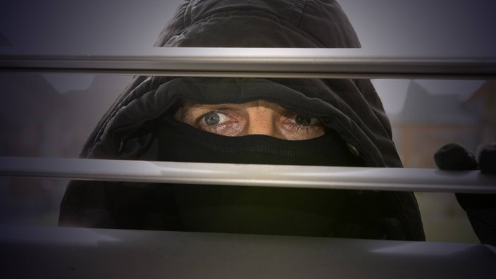 Einbrecher schaut durch Rollläden | Bildquelle: imago/imagebroker Einbrecher schaut durch Rollläden