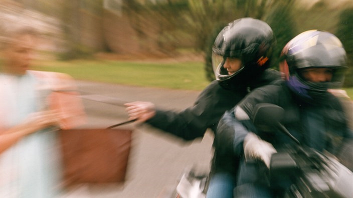 Zwei Männer auf einem Roller klauen eine Tasche einer Frau. | Bildquelle: WDR Zwei Männer auf einem Roller klauen eine Tasche einer Frau.