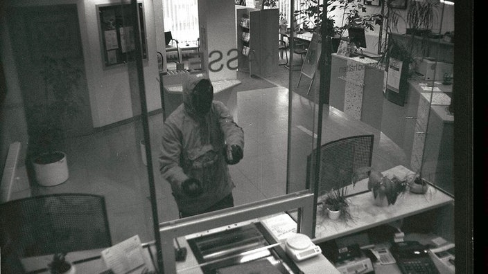 Vermummter Bankräuber droht mit Waffe | Bildquelle: dpa Picture-Alliance Vermummter Bankräuber droht mit Waffe