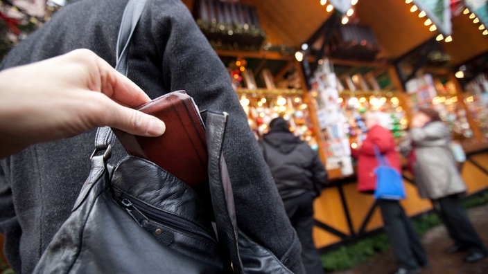 Jemand klaut eine Geldbörse aus einer Handtasche | Bildquelle: WDR/dpa/Frank Rumpenhorst Jemand klaut eine Geldbörse aus einer Handtasche