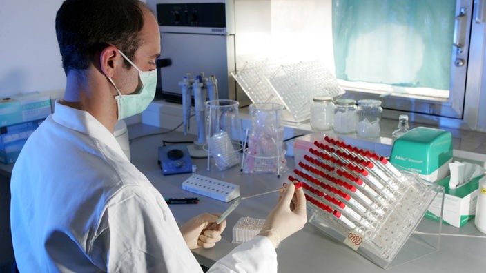 Mann in weißem Kittel im Labor.