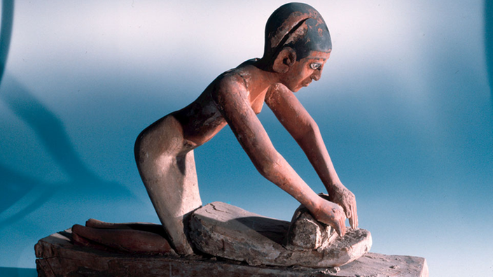 Ägyptische Holzfigur einer Sklavin beim Kornmahlen, etwa 2000 - 1750 vor Christus.
