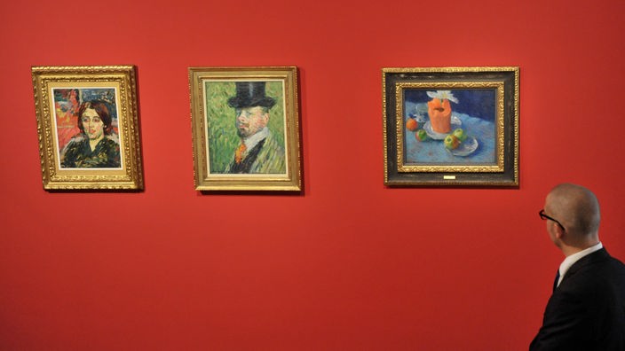 Ein Mann vor drei Jawlensky-Bildern in einer Ausstellung