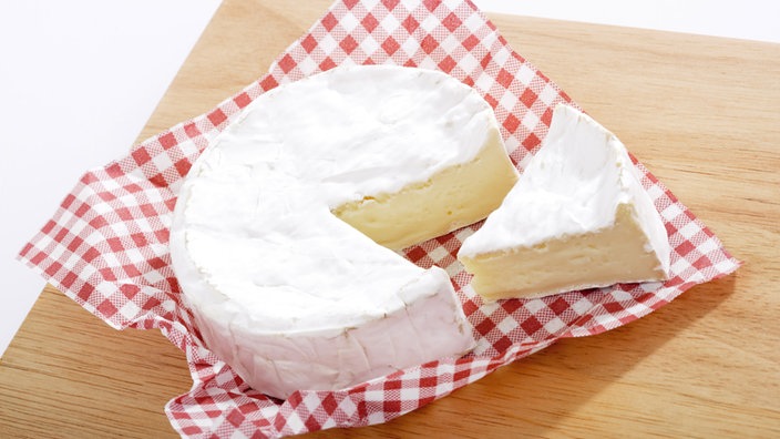 Ein Stück Camembert auf seiner rot-weiß-karierten Verpackung | Bildquelle: WDR / MEV Ein Stück Camembert auf seiner rot-weiß-karierten Verpackung