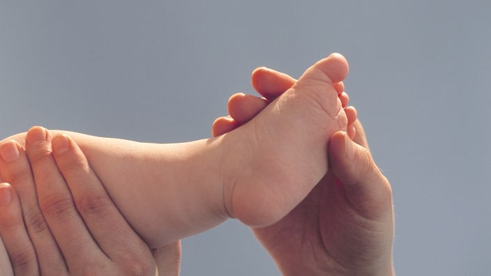 Ein Baby wird am Fuß massiert