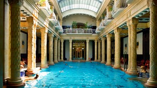 Thermalbad in Budapest mit kunstvoll verzierten Säulen und Glasdach.