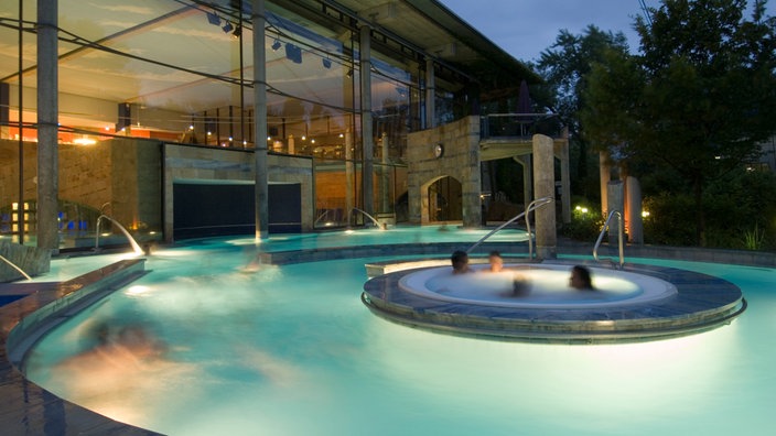 Beleuchtetes Außenbecken der Claudius-Therme in Köln.