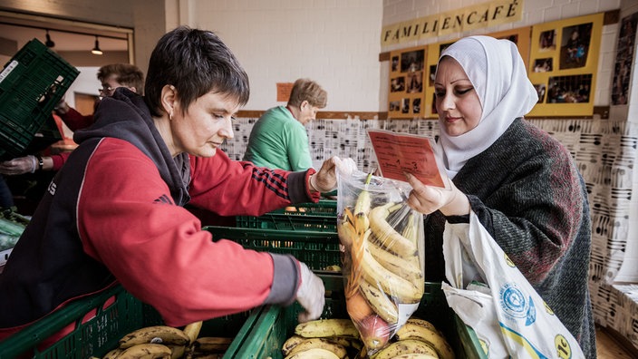 Eine Kundin wird von einer Helferin der Tafel bedient | Bildquelle: Tafel/Dagmar Schwelle Eine Kundin wird von einer Helferin der Tafel bedient