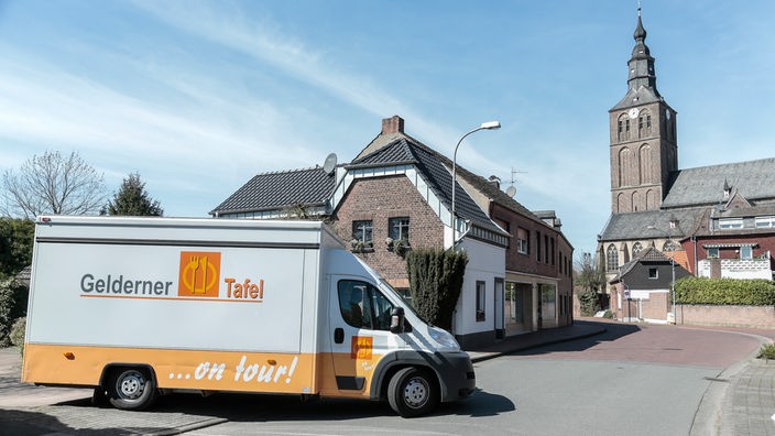 Ein großes Auto fährt als mobiler Marktstand der Tafel durch Geldern am Niederrhein