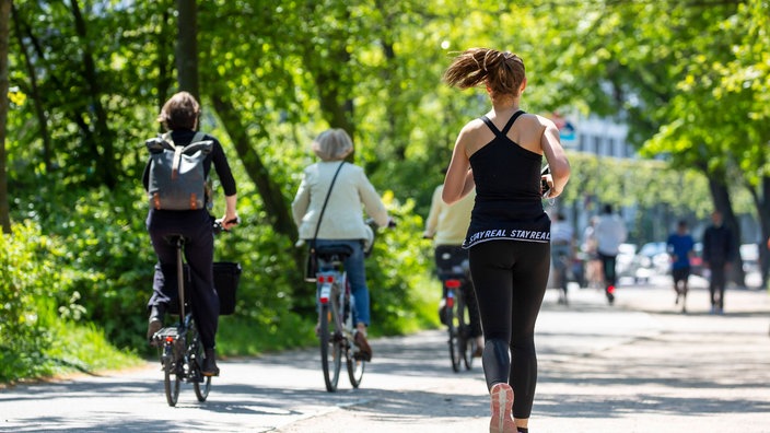 Eine Joggerin und Fahrradfahrer auf einem Weg. | Bildquelle: imago Eine Joggerin und Fahrradfahrer auf einem Weg.