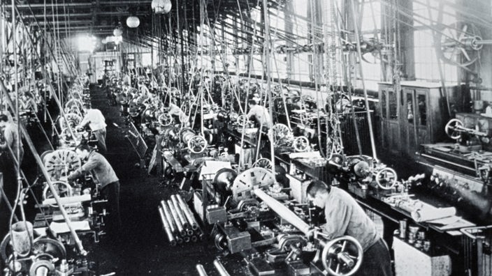 In einer Werkshalle der Essener Kruppwerke stehen Arbeiter an Maschinen (um das Jahr 1900)