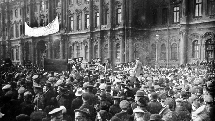 Eine Menschenmenge steht 1917 vor dem Petrograder Winterpalast. Auf einem Transparent steht auf russisch "Gebt Brot!" | Bildquelle: imago stock&people Eine Menschenmenge steht 1917 vor dem Petrograder Winterpalast. Auf einem Transparent steht auf russisch "Gebt Brot!"