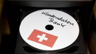 Daten-CD mit Schweizer Flagge in einem offenen Computer-Laufwerk.