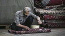 Ein Mann arbeitet an einem Teppich auf einem Teppichbasar in Teheran