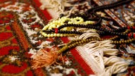 Islamische Gebetsketten liegen auf einem Gebetsteppich