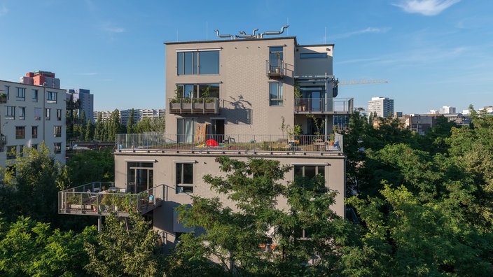 Wohnhaus umrahmt von grünen Bäumen | Bildquelle: Katja Hoffmann/laif Wohnhaus umrahmt von grünen Bäumen