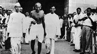 Mahatma Gandhi verlässt ein Gebäude.