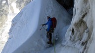 EIn Mensch in einer Gletscherspalte an den Grandes Jorasses im Mont-Blanc Massiv