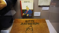 Karikaturen von Helmut Kohl. Ein Fußabtreter auf dem steht: "Bitte abtreten"