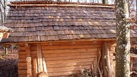 Eine aus Balken aufgebaute Holzhütte mit Schindeldach aus Holz