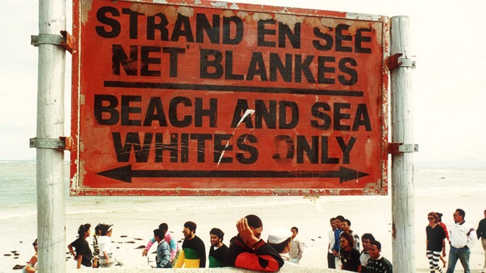 Schild am Strand mit der Aufschrift "Beach and sea - Whites only".