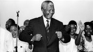 Schwarzweiß-Bild von Nelson Mandela, der lacht und tanzt.