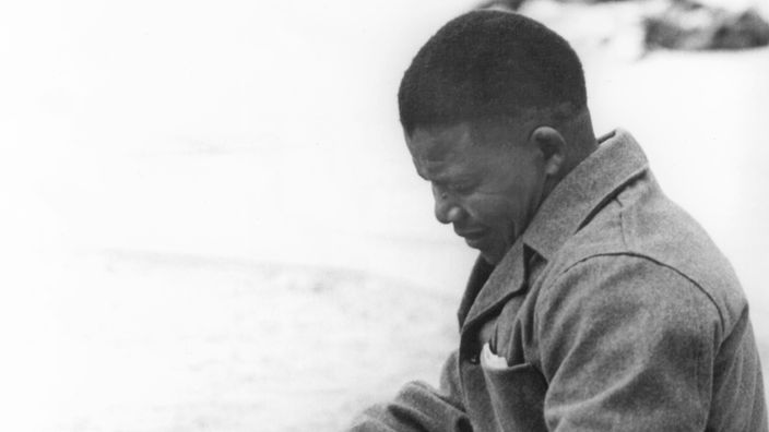 Der junge Nelson Mandela beim Ausbessern von Gefängniskleidung