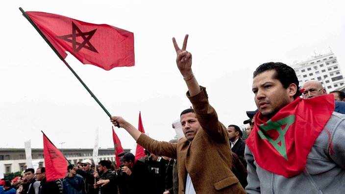 Demonstranten mit marokkanischer Flagge am "Tag des Stolzes" in Casablanca 2011 | Bildquelle: picture alliance / dpa Demonstranten mit marokkanischer Flagge am "Tag des Stolzes" in Casablanca 2011