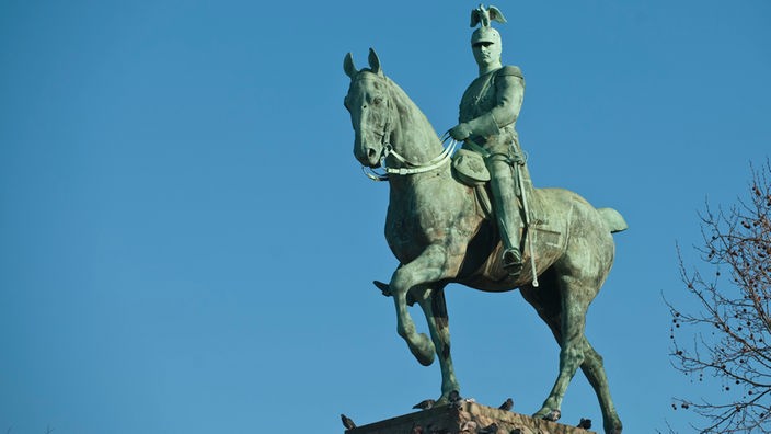 Eine große Reiterstatue thront auf einem steinernen Sockel.