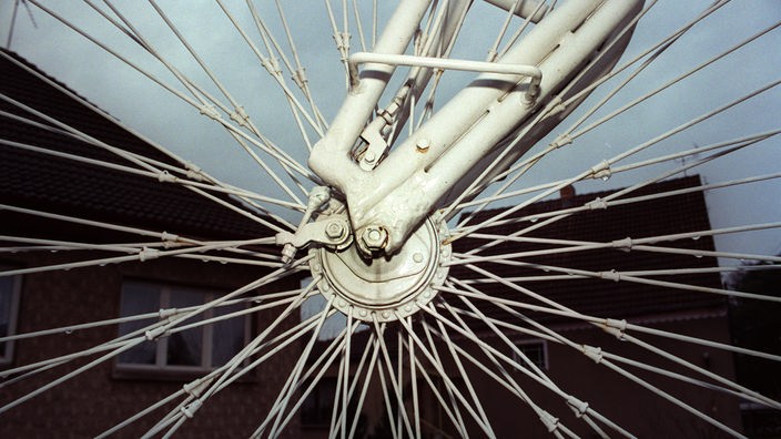 Ganz nah kann man die vielen einzelnen silbernen Speichen erkennen, die einen Fahrradreifen stabil machen.