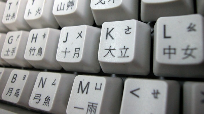 Auf der Computertastatur sind neben den lateinischen Buchstaben auch chinesische Schriftzeichen zu sehen