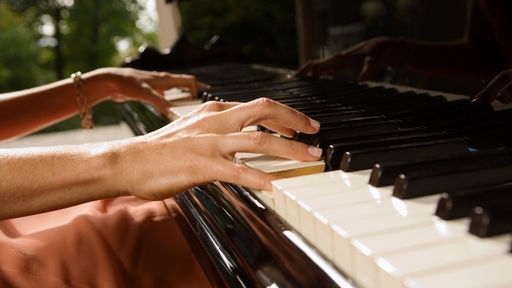Nahaufnahme von Frauenhänden beim Klavierspielen 