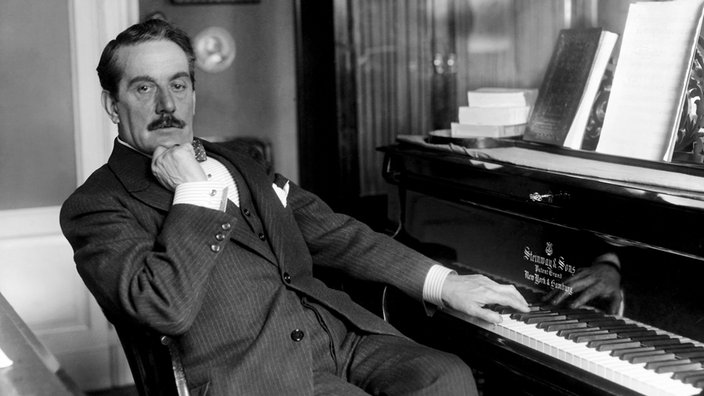 Ein Schwarzweiß-Foto zeigt den italienischen Komponisten Giacomo Puccini am Klavier. | Bildquelle: Interfoto/Fratelli Alinari Business Ein Schwarzweiß-Foto zeigt den italienischen Komponisten Giacomo Puccini am Klavier.