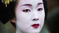 Porträt einer Geisha, die traditionell geschminkt ist