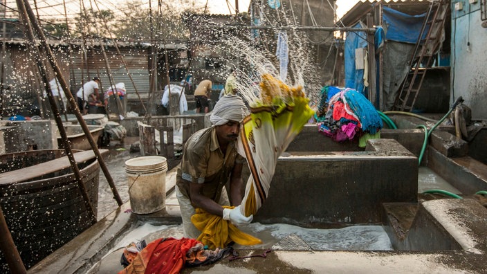 Ein Wäscher bei der Arbeit in Mumbai | Bildquelle: picture alliance / Photoshot Ein Wäscher bei der Arbeit in Mumbai