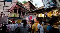 Menschen gehen über einen Markt in Kalkutta.