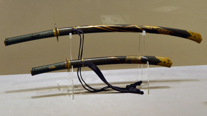 In einer Halterung liegen zwei Samurai-Schwerter, das große Katana und darunter das kürzere Wakizashi.