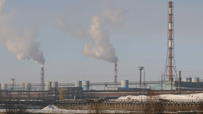 Rauchende Schlote eines Aluminiumwerkes in einem Vorstadtgebiet von Irkutsk.